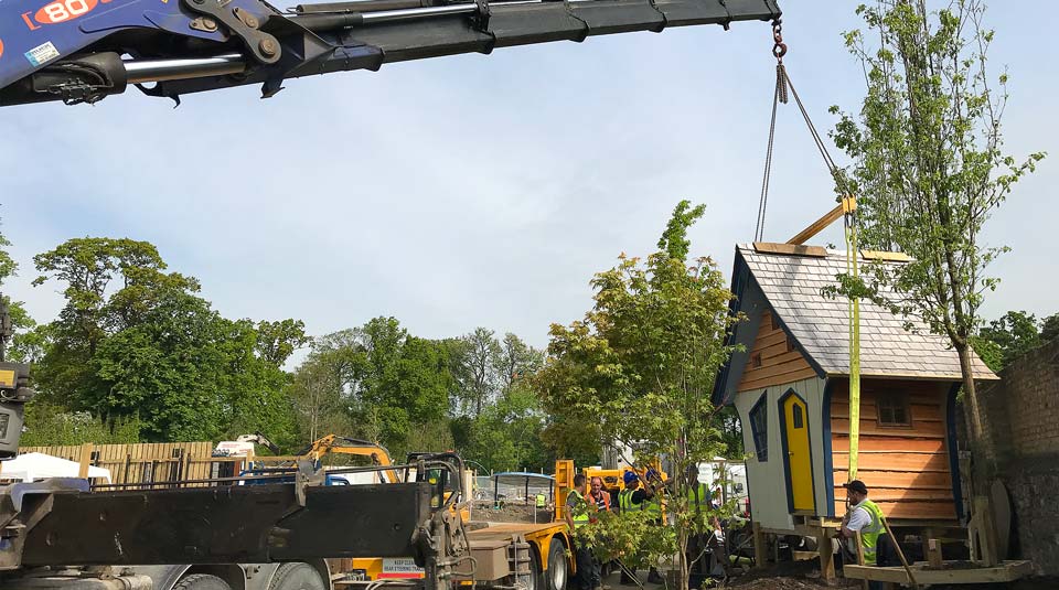 A crane lifts the prefabricated treehouse into place in Bloom 2018